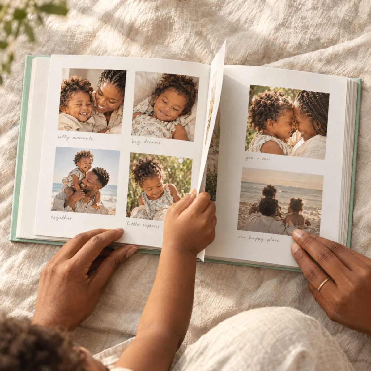 A parent and child turn the pages of a mint photo book filled with family photographs and handwritten captions.